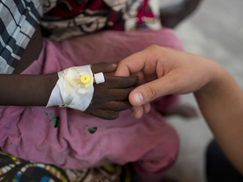 photo of a child patient holding hand of an adult