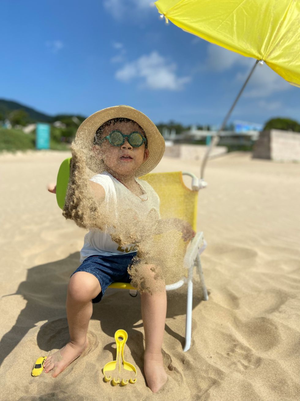 Photo of a child playing in the sand during the summer.