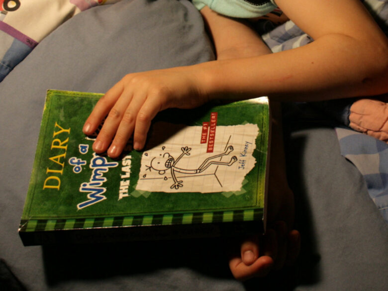 Photo of a child reading Diary of a Wimpy Kid