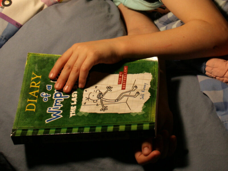 Photo of a child reading Diary of a Wimpy Kid