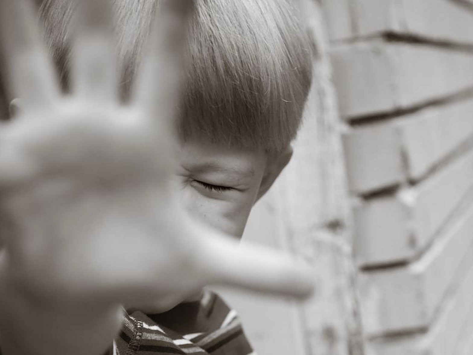 Photo of a child screaming, blocking the camera