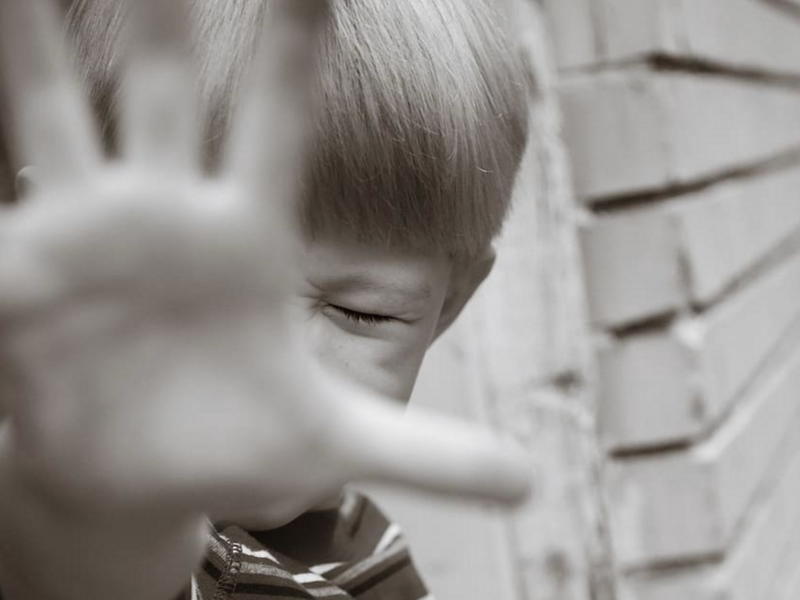 Photo of a child screaming, blocking the camera