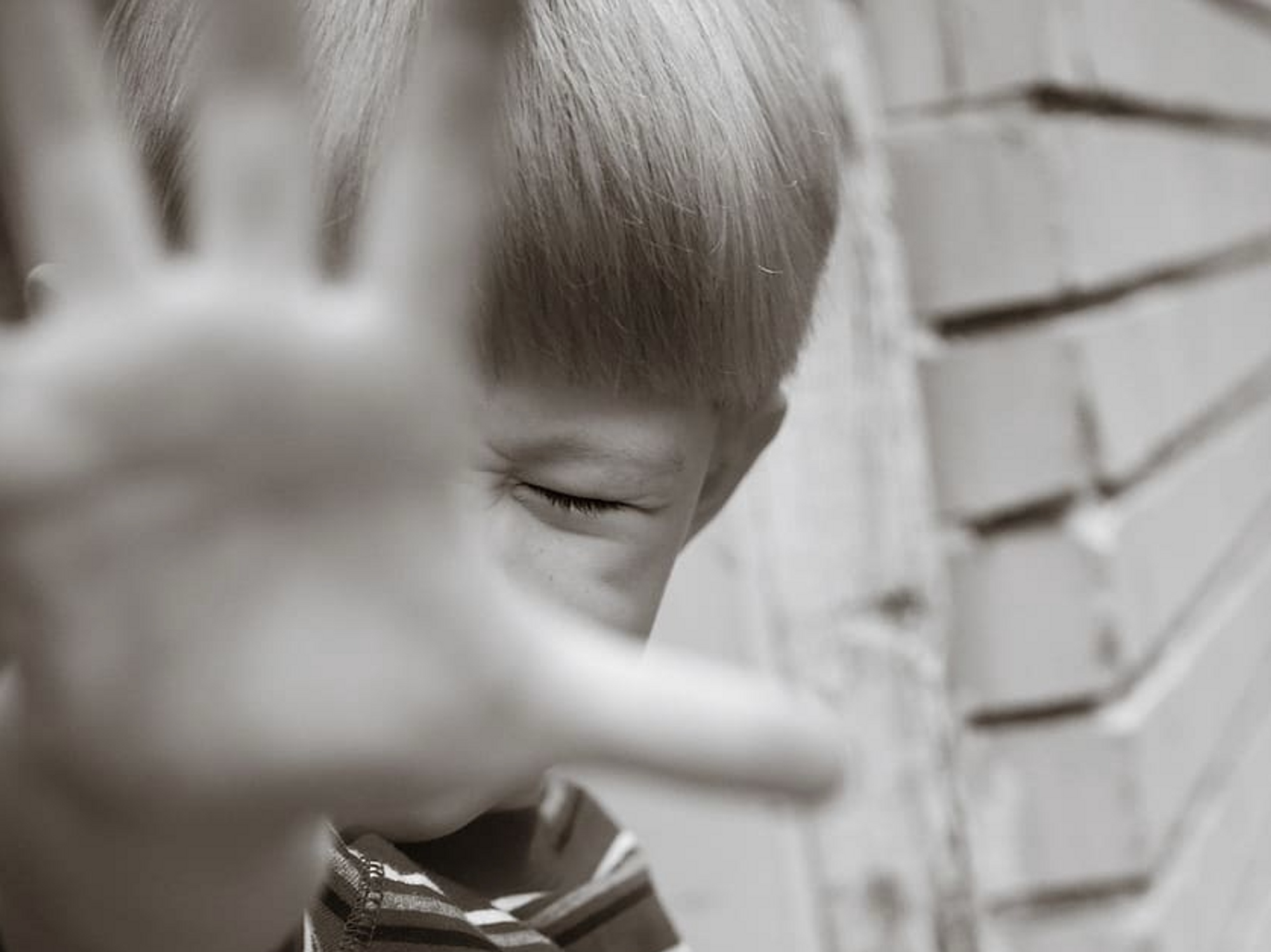 Photo of a child screaming, blocking the camera