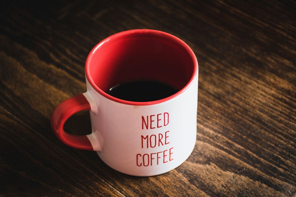 Photo of a coffee mug bearing the inscription "NEED MORE COFFEE"