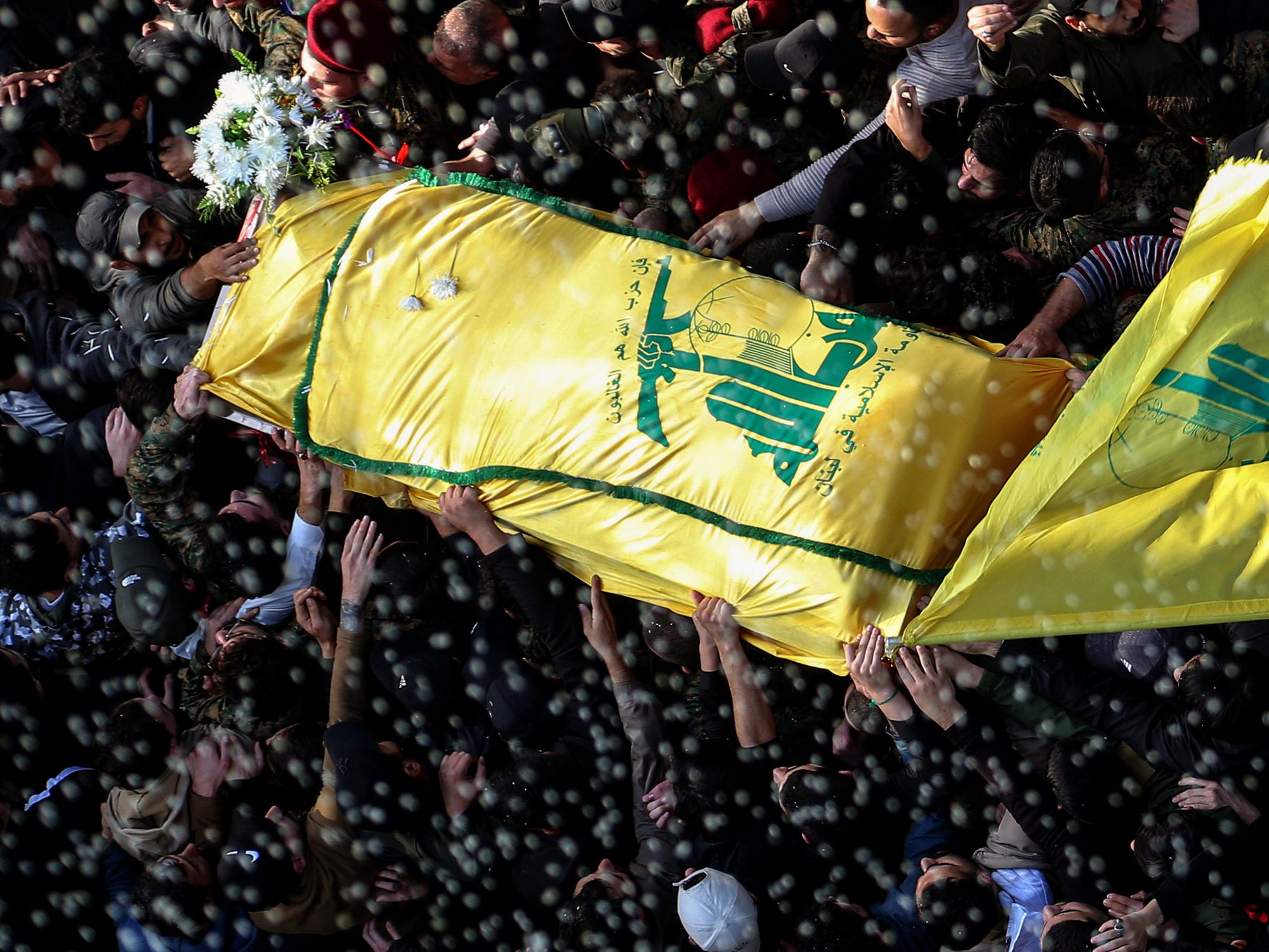 Photo of a crowd carrying the coffin of top commander Wissam al-Tawil during his funeral procession in the southern Lebanese village of Khirbit Selem.