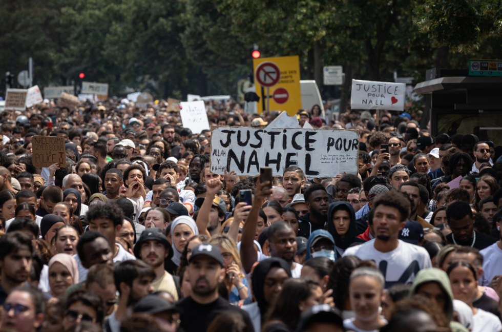 Photo of a crowd displaying signs that read "Justice for Nahel" in Nanterre on June 29
