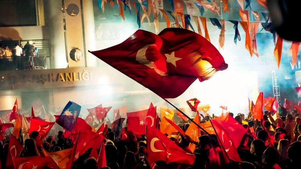 Photo of a crowd of AKP waving flags and celebrating election results in Izmir, Turkey.