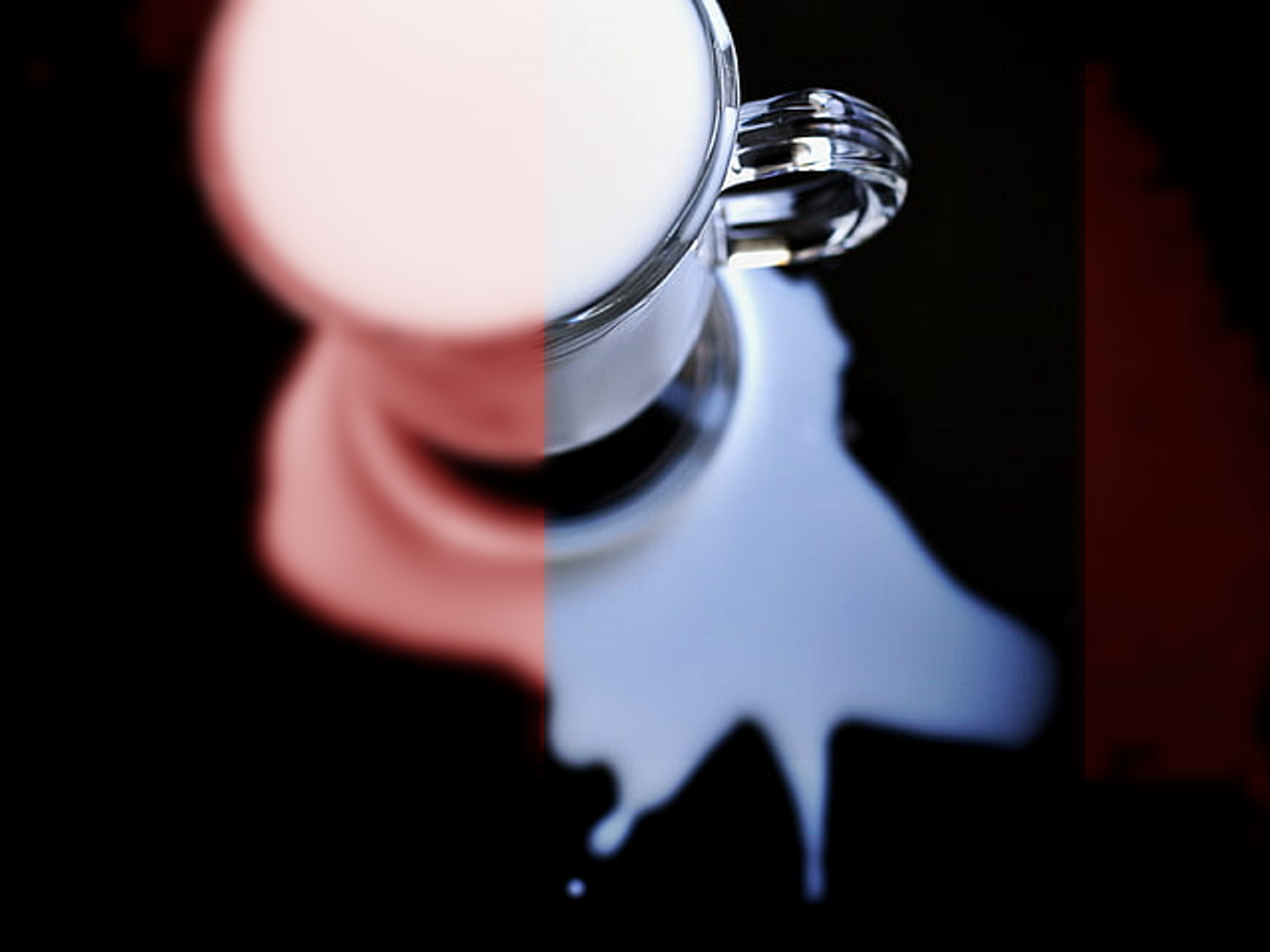 Photo of a cup of milk with some having spilled over