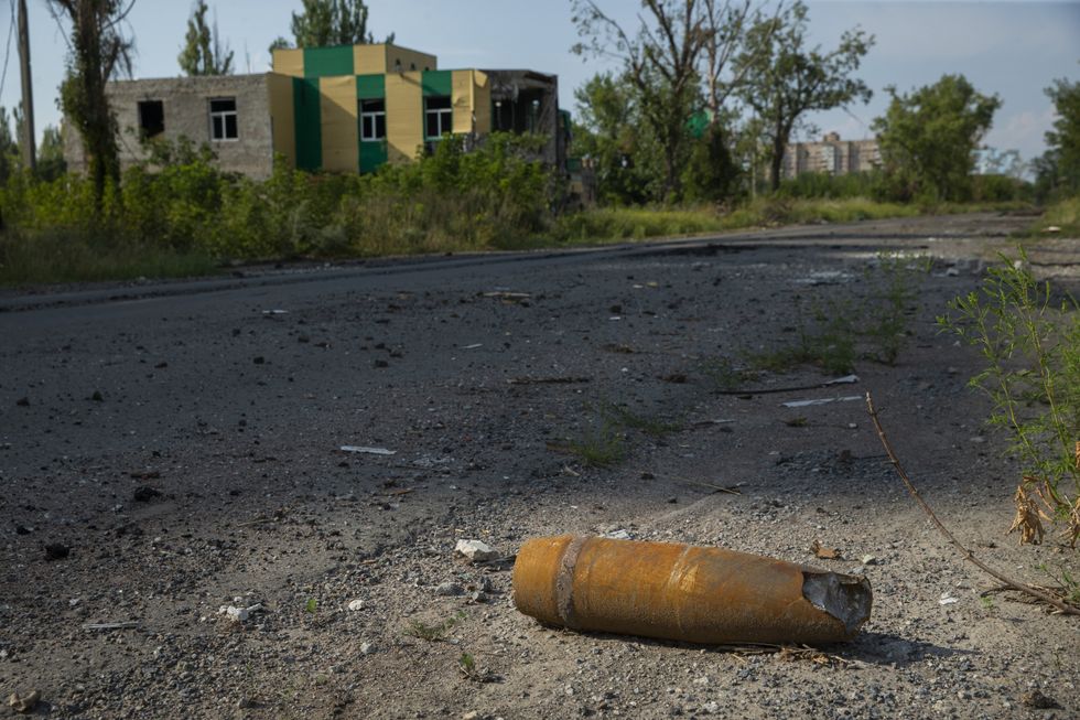 Photo of a damaged and unexploded shell sitting on a road near a residential neighborhood in Avdiivka, Ukraine.