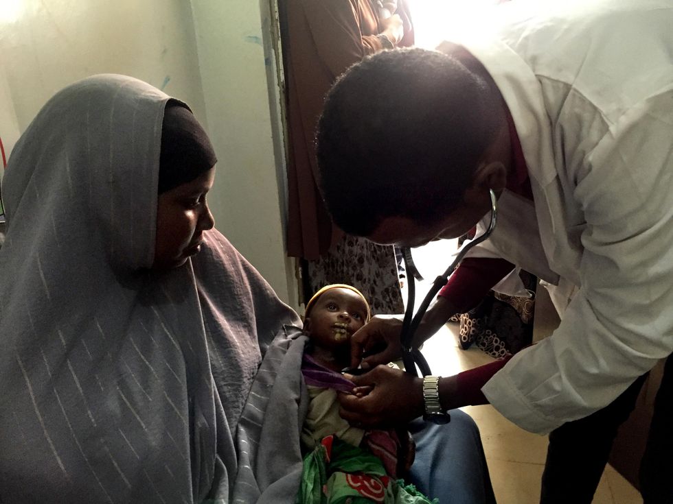 Photo of a doctor examining a baby in Somalia
