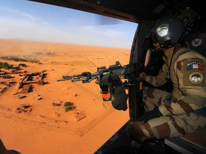 Photo of A ​French soldier manning a gun, aboard a Puma helicopter flying over Madama, northern Niger