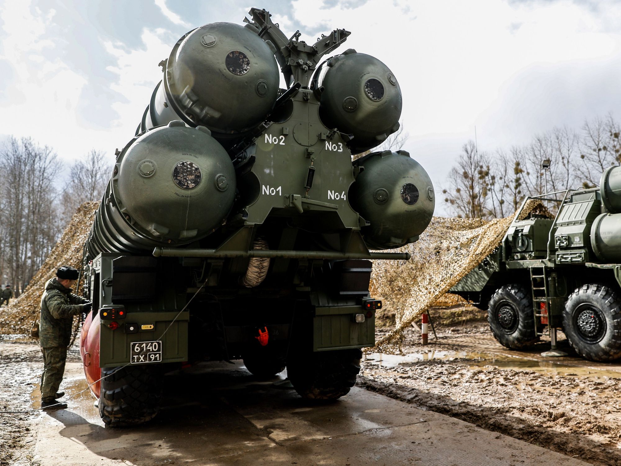 Photo of a ​Russian soldier standing next to army vehicles carrying missiles in the Russian semi-exclave of Kaliningrad