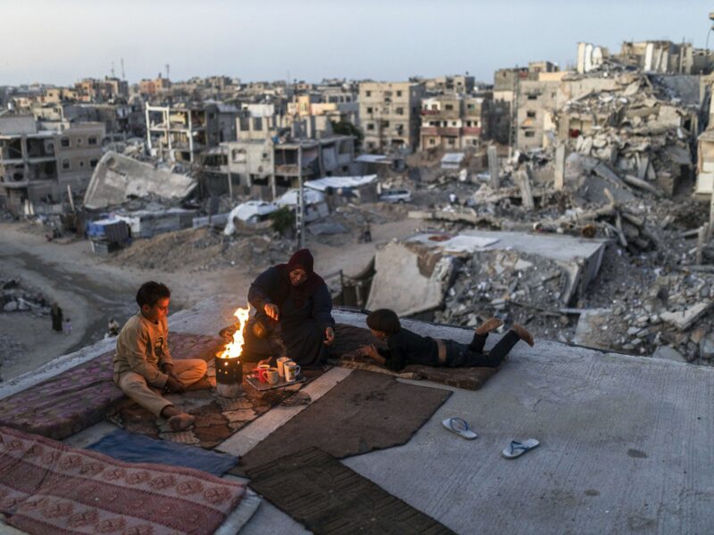 photo of a family with a fire drinking tea
