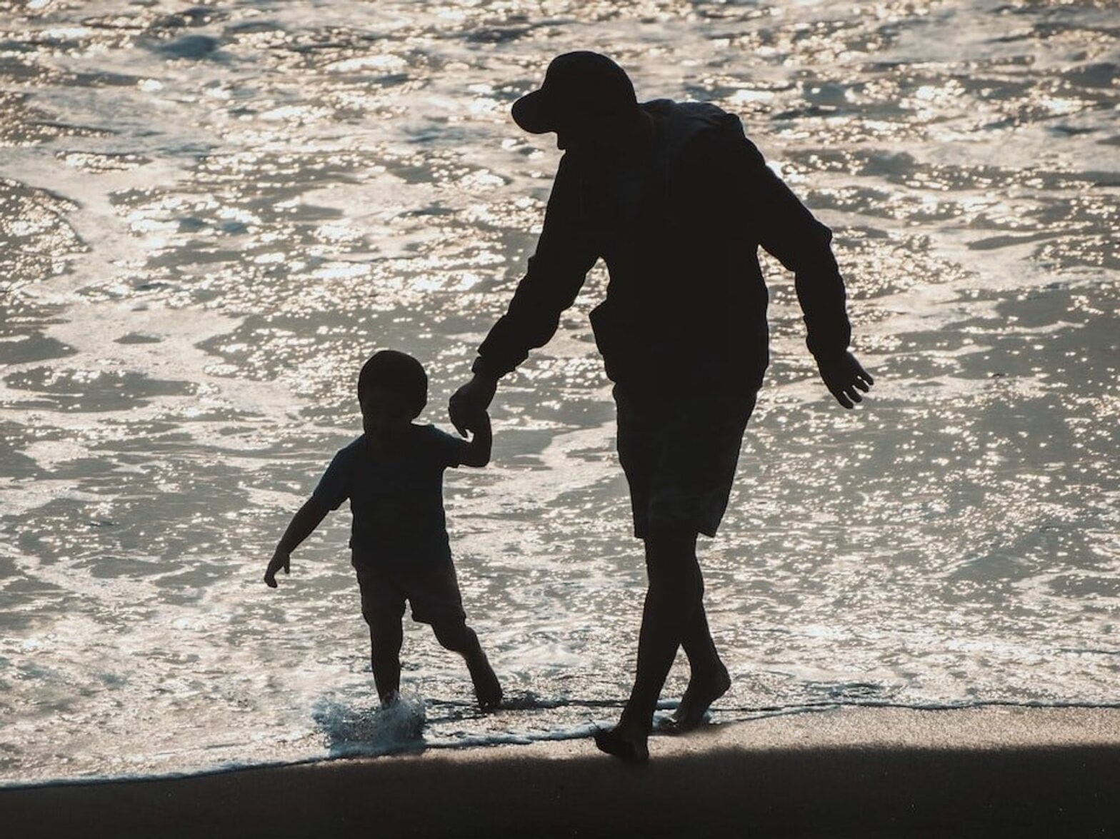 Photo of a father and son on the beach. ​