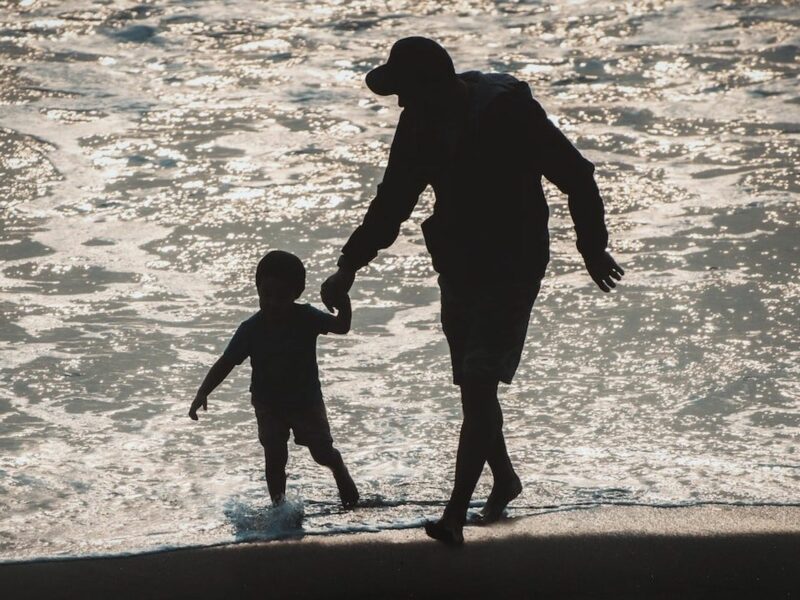 Photo of a father and son on the beach. ​