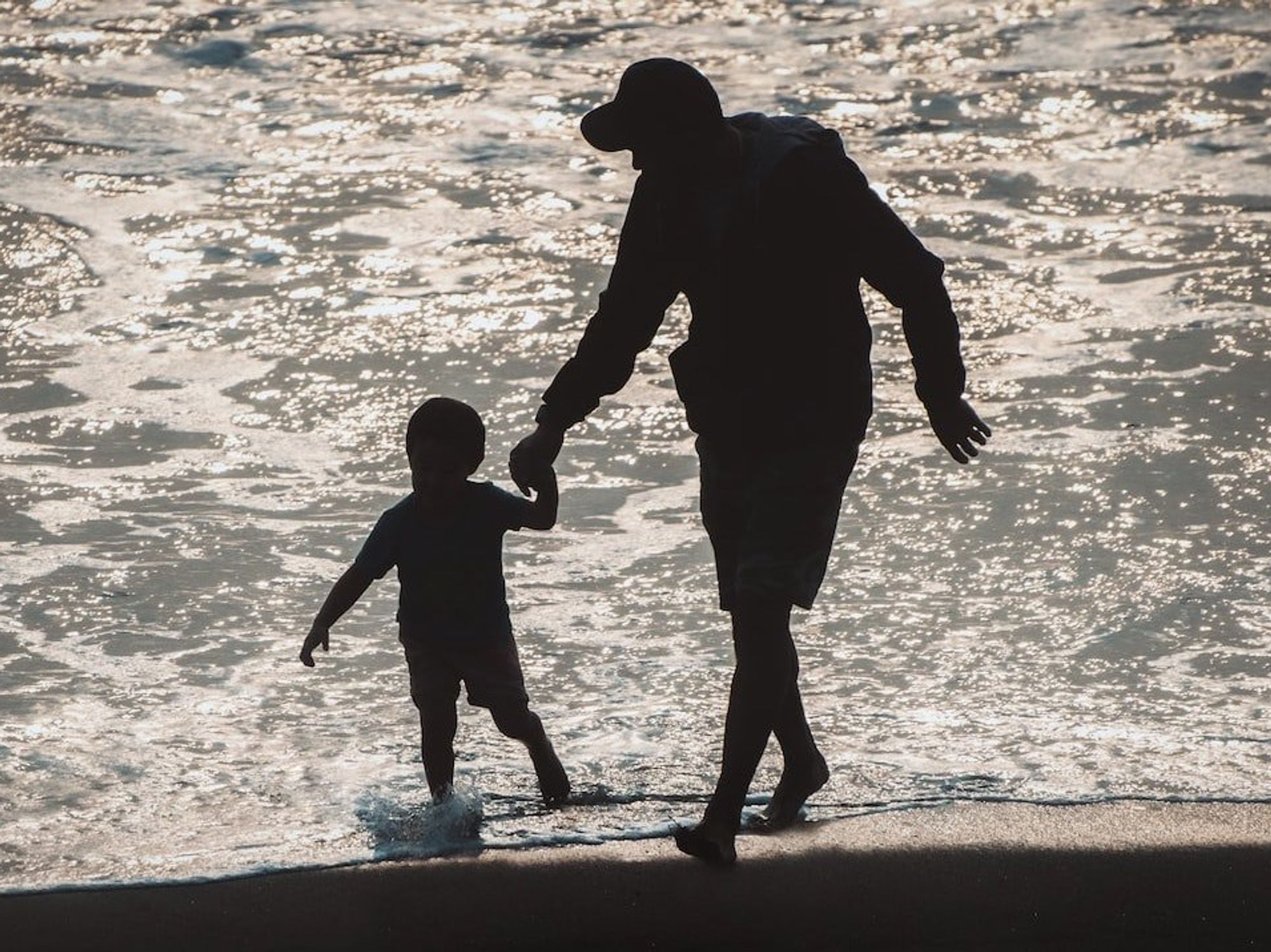 Photo of a father and son on the beach. ​