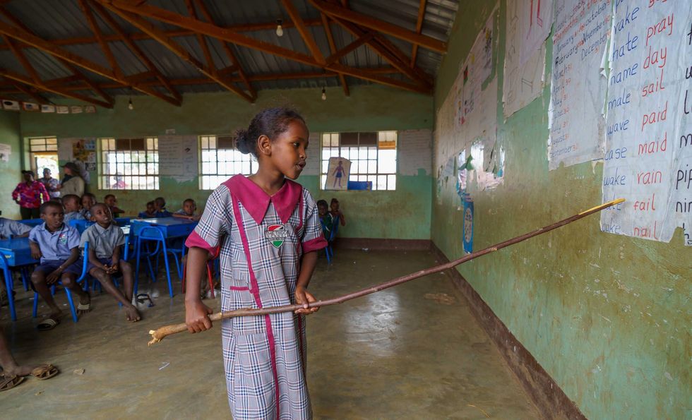 Photo of a female student pointing to the board with a stick