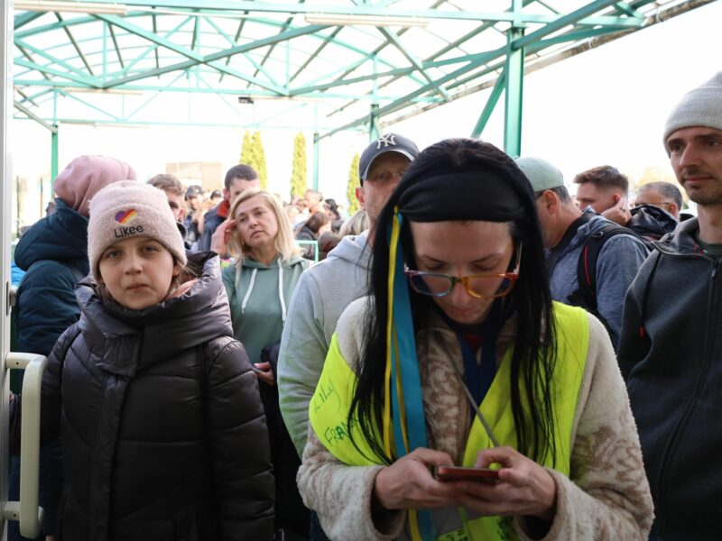 photo of a girl in a hat and a woman in a vest at poland-ukraine border