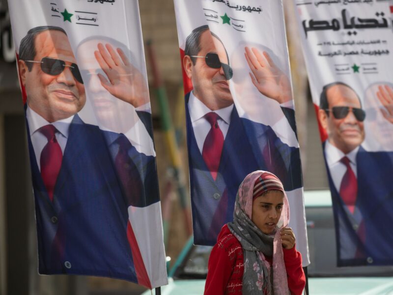 photo of a girl in front of posters for el-sisi