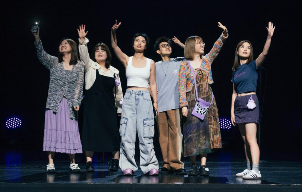 Photo of a group of stand-up comedians saluting the crowd after performing at Beijing's ​Laughing Fruit Factory