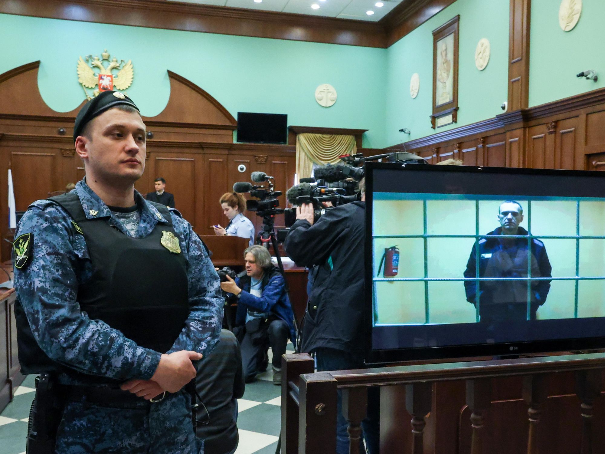 photo of a guard in a moscow court as Alexei Navalny appears by video link