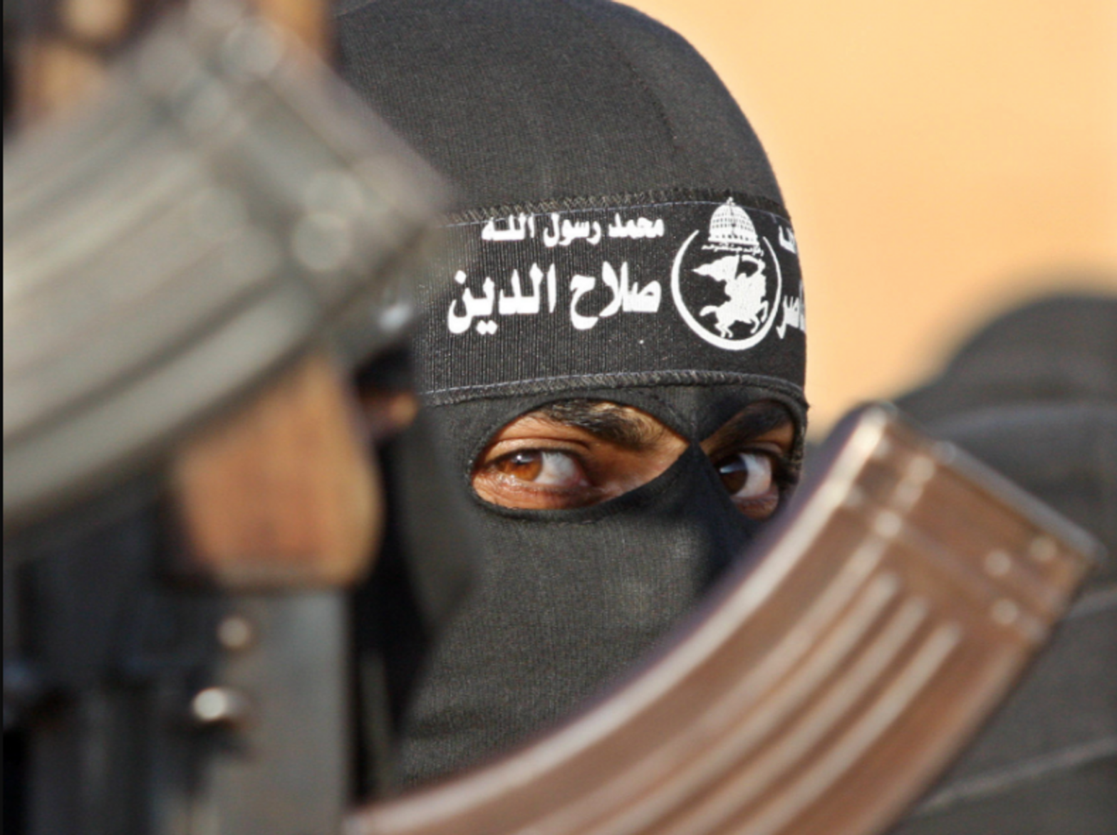 Photo of a Hamas member next to a Russian-made rifle