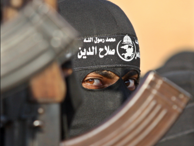 Photo of a Hamas member next to a Russian-made rifle