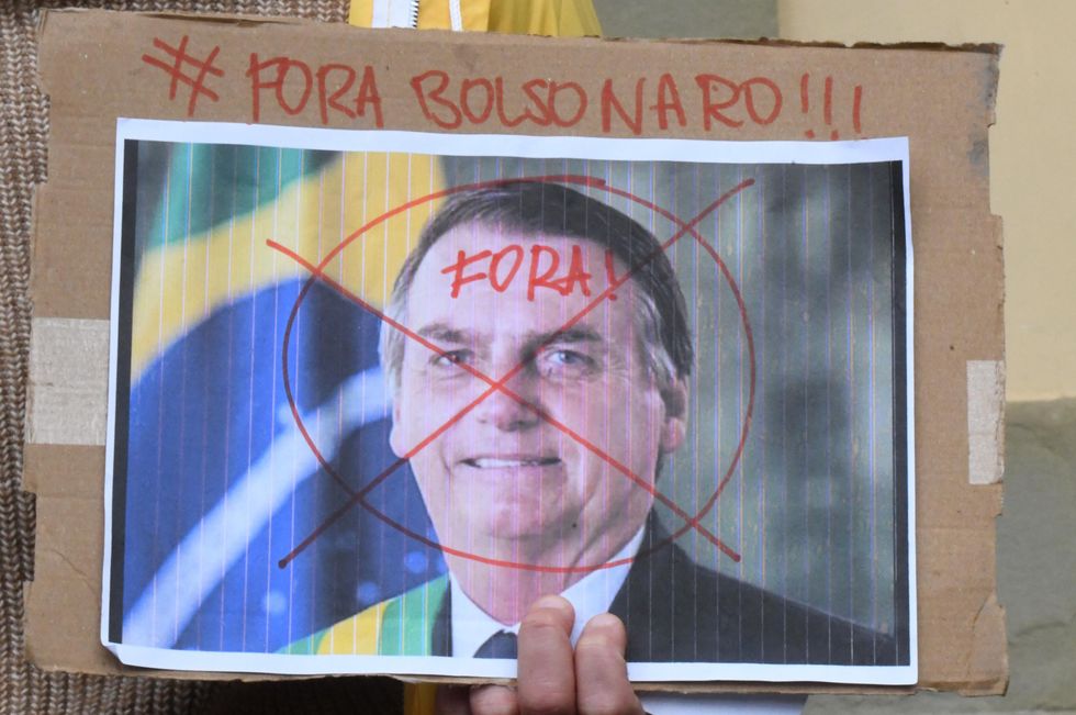 Photo of a hand holding a sign with Brazilian President Jair Bolsonaro's face, with the slogan "Out Bolsonaro!!!"