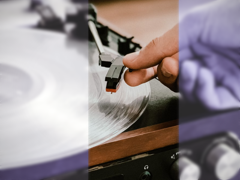 Photo of a hand picking up the needle on a turntable