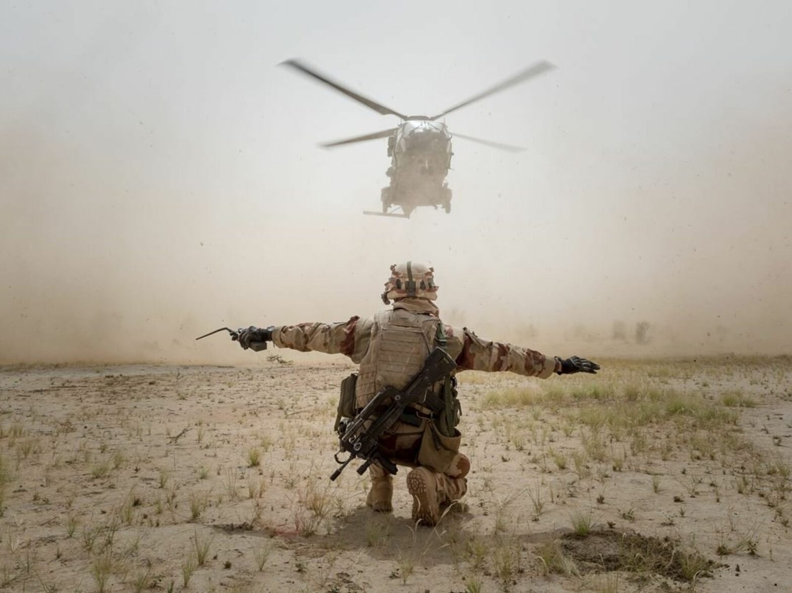 Photo of a helicopter landing, guided a member of France's ​Operation Barkhane in the Sahel region