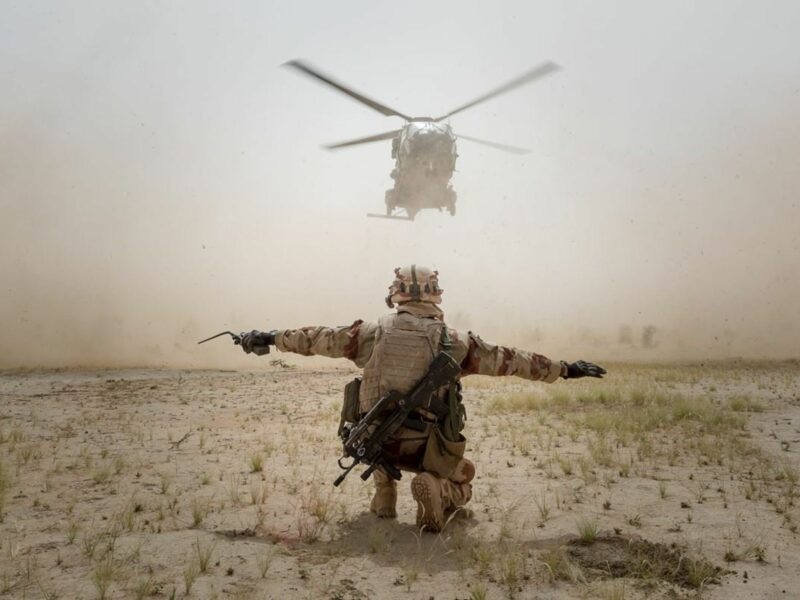 Photo of a helicopter landing, guided a member of France's ​Operation Barkhane in the Sahel region