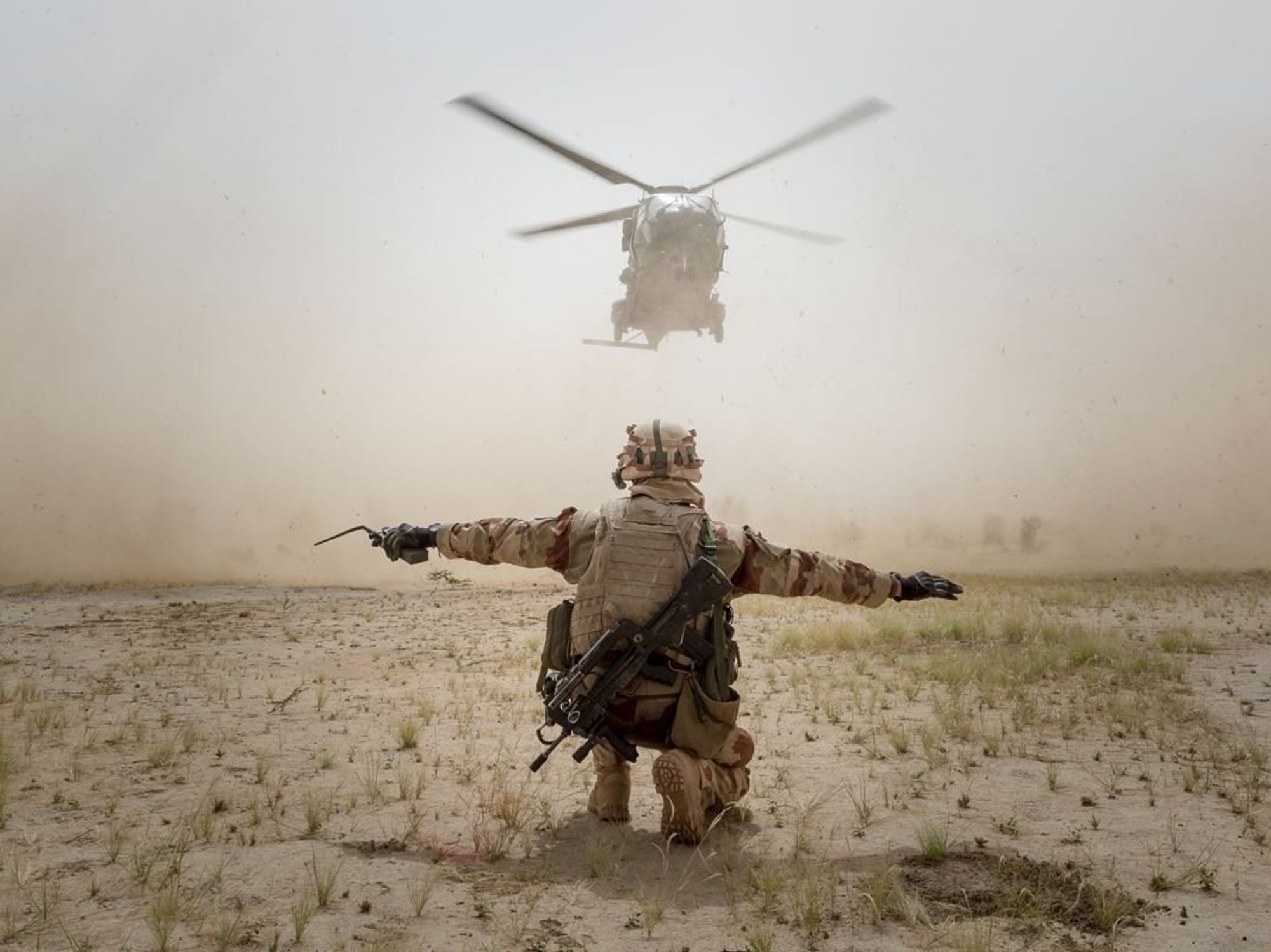 Photo of a helicopter landing, guided a member of France's ​Operation Barkhane in the Sahel region
