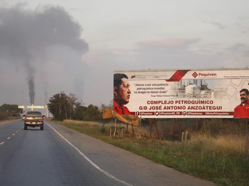 photo of a highway with a billboard and smoke in the distance