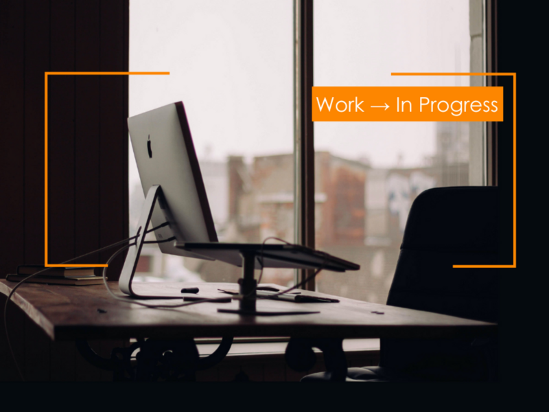 Photo of a laptop on an office desk with an empty chair