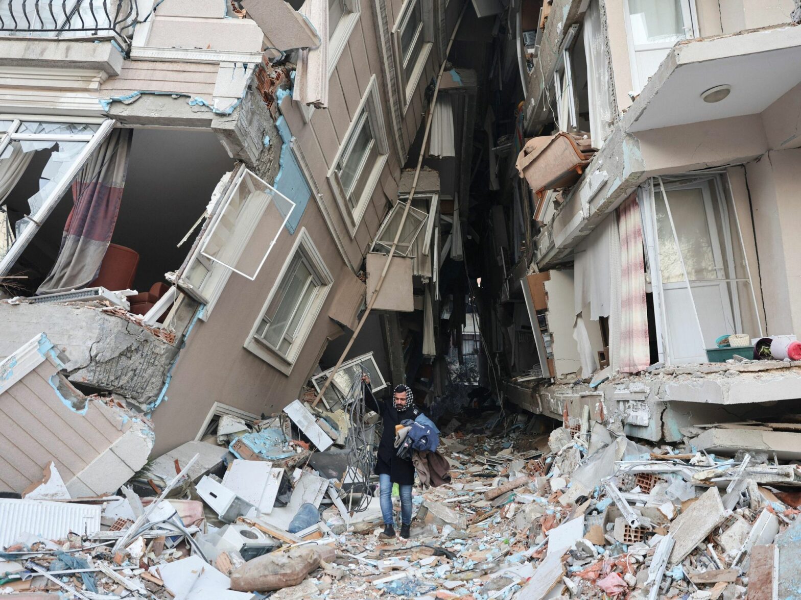 Photo of a man between destroyed buildings after Turkey earthquake
