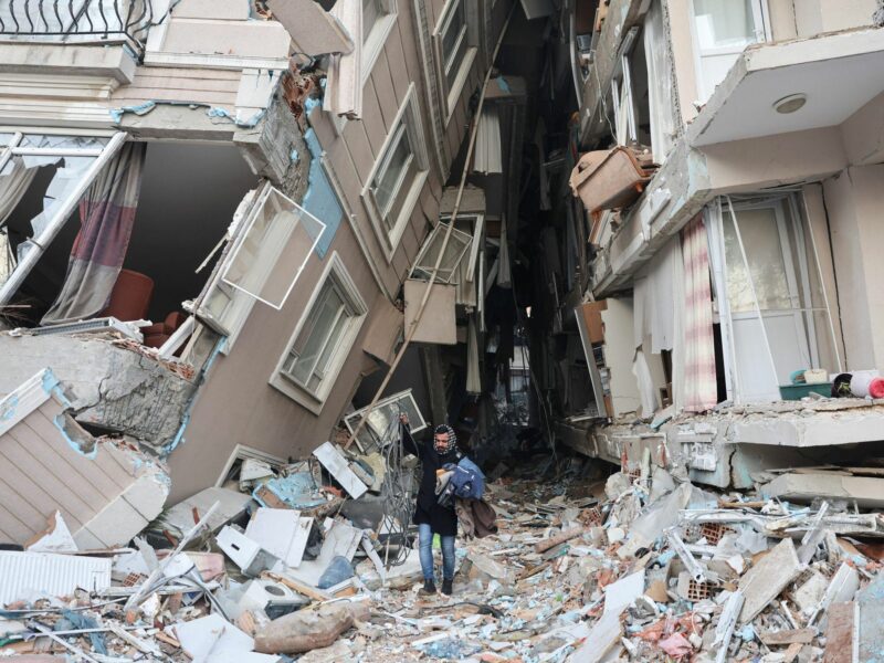 Photo of a man between destroyed buildings after Turkey earthquake