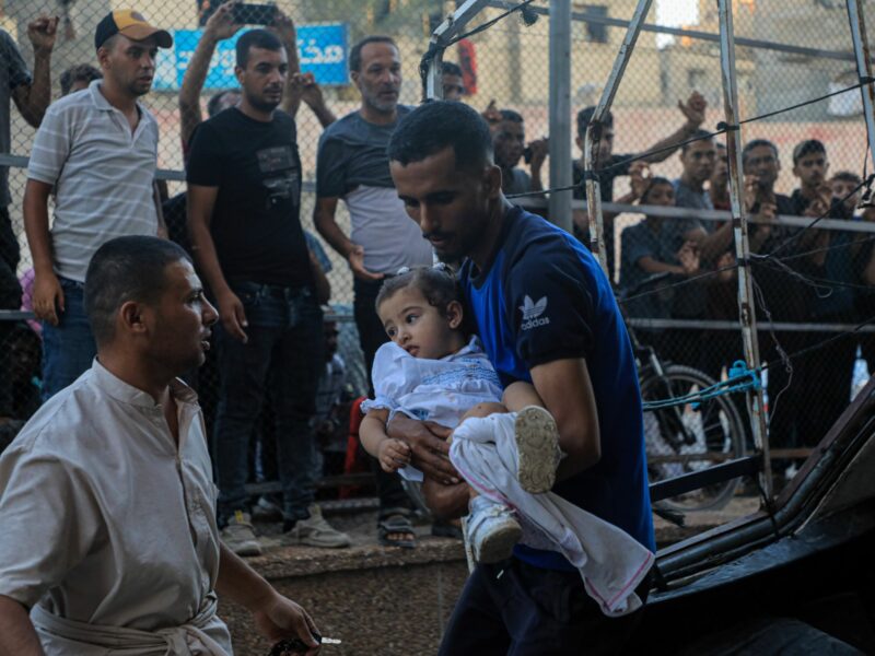 photo of a man carrying an injured girl