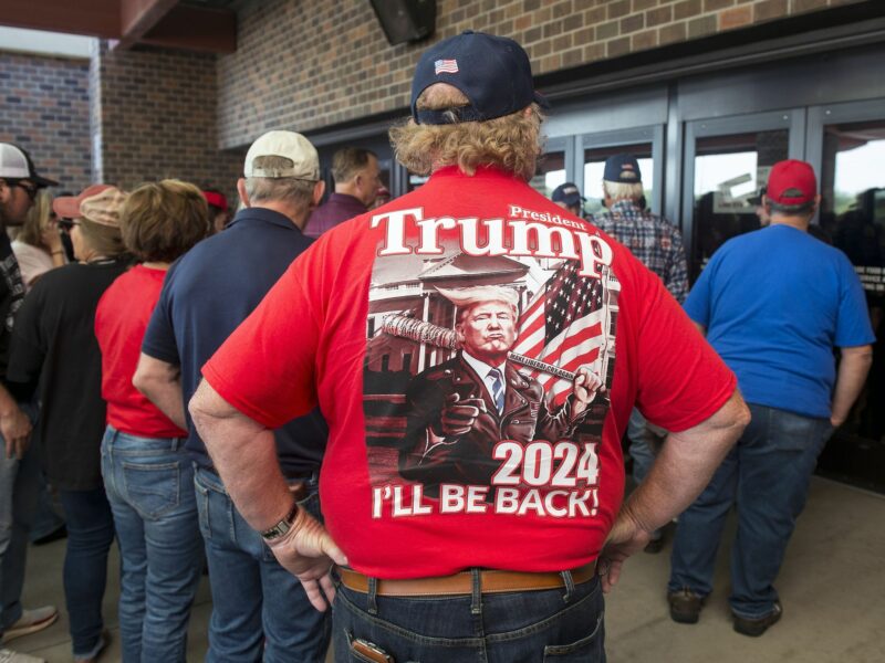 photo of a man from behind with a red trump shirt