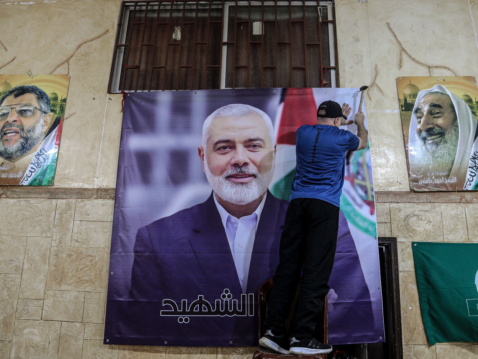 photo of a man hanging a giant poster