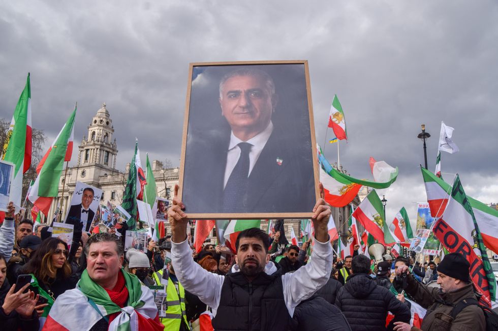 Photo of a man holding a picture of Reza Pahlavi, the exiled Crown Prince of Iran