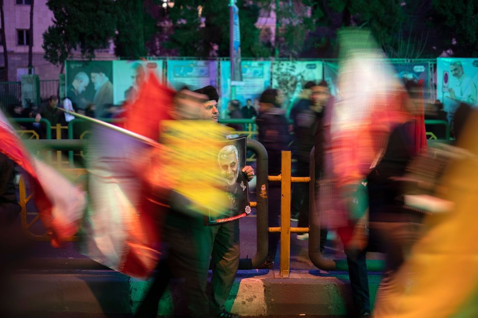 Photo of a man holding a portrait of Qasem Soleimani during a January 2020 protest in Tehran, Iran.