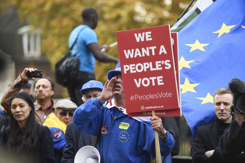 photo of a man holding a sign and shouting