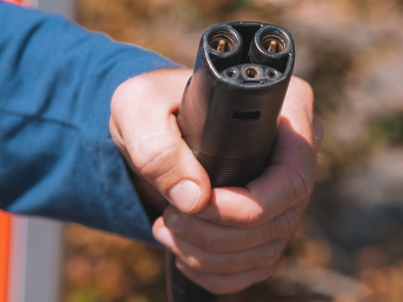 Photo of a man holding an EV lectric plug