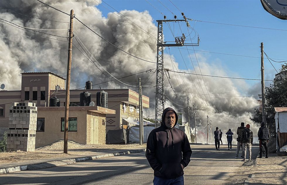 photo of a man in a hoodie with smoke behind him