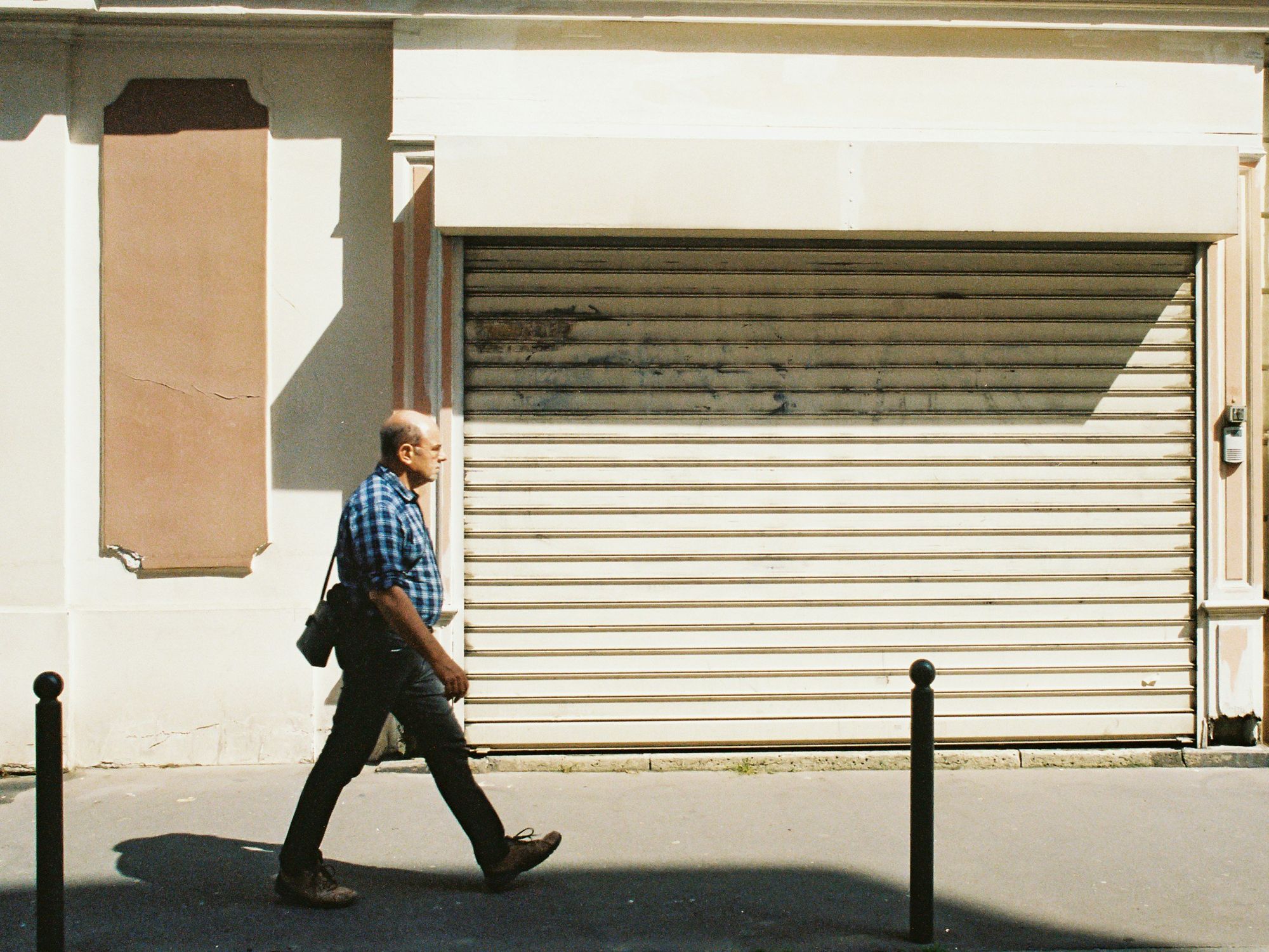 Photo of a man in France walking past a closed shop