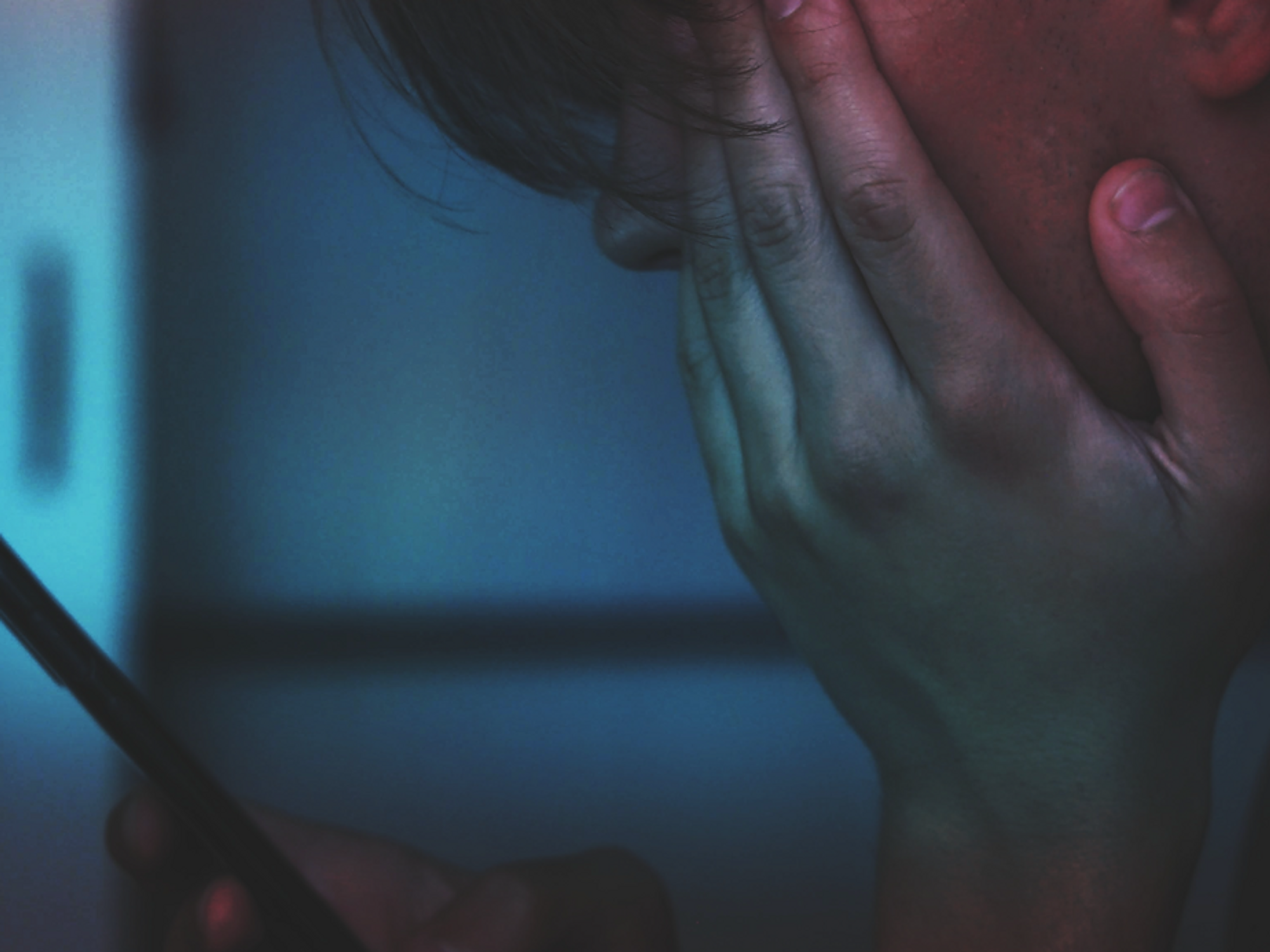 Photo of a man looking down at his phone