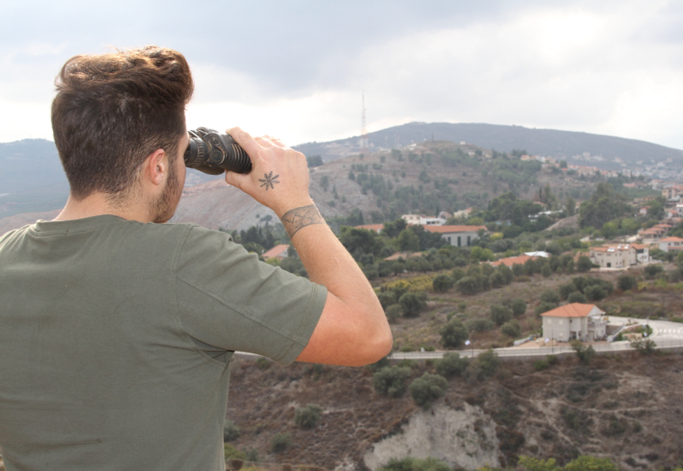Photo of a man looking over the border with Israel from the Marjayoun area in south Lebanon, on Oct. 11.