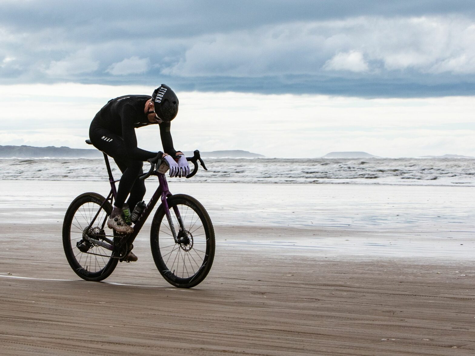 photo of a man on a bicycle along the seashore