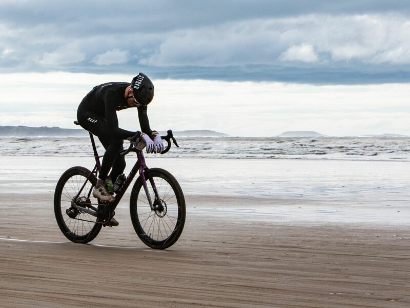 photo of a man on a bicycle along the seashore