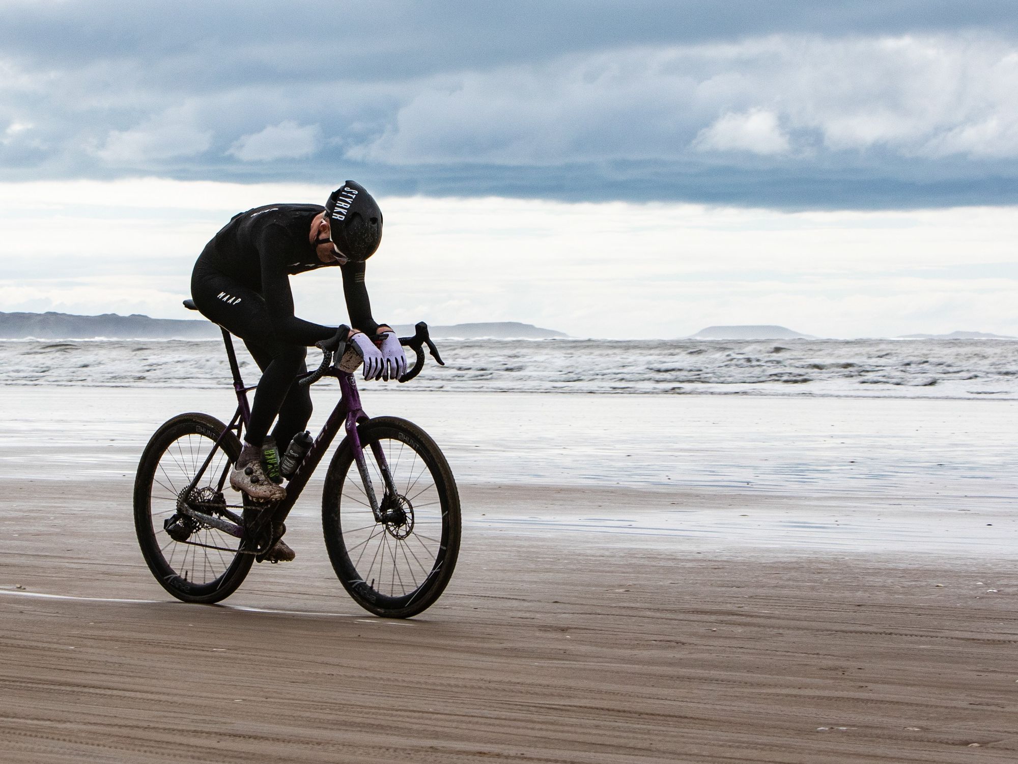 photo of a man on a bicycle along the seashore